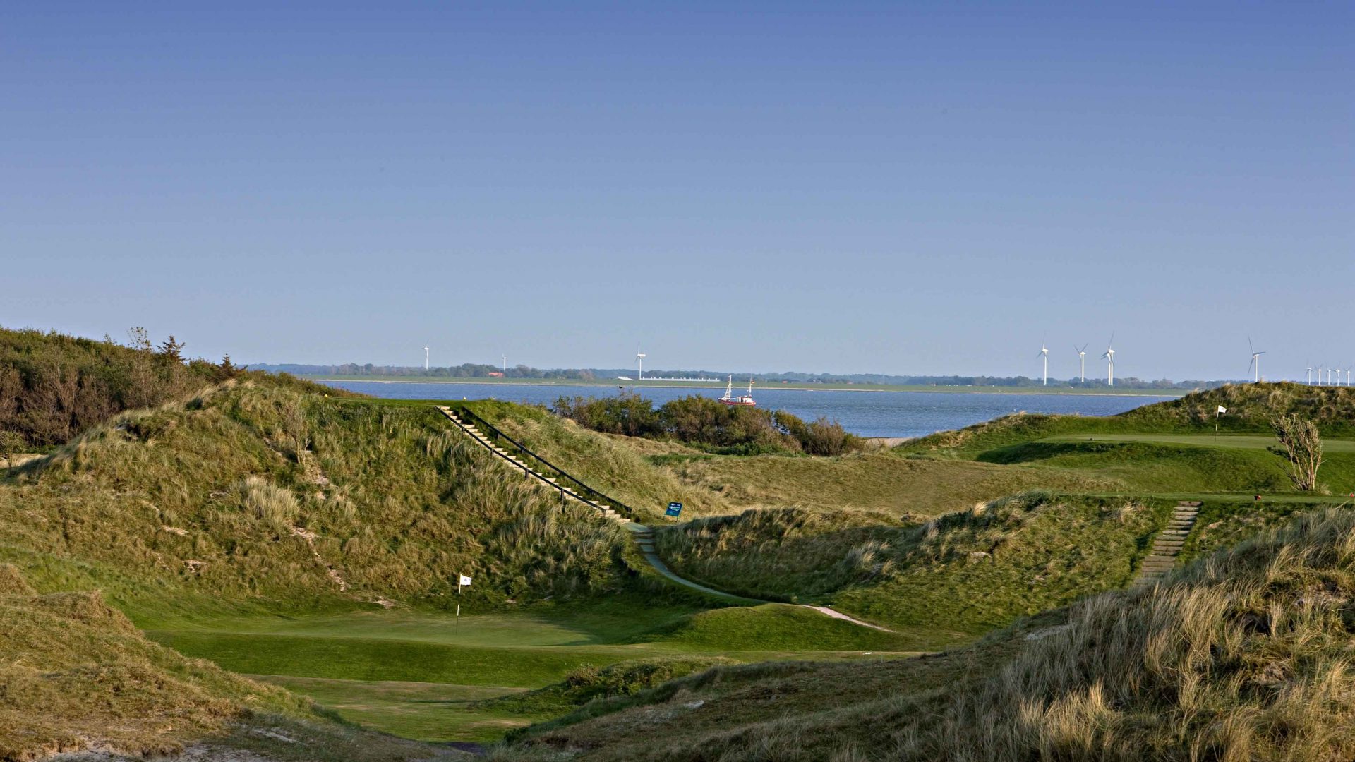 GC Norderney  vom erhöhten Abschlag genießt man einen herrlichen Blick aufs 5. und 1. Grün (rechts) - und das Wattenmeer.