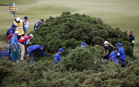 Players, officials and caddies look for Ernie Els's ball in the gorse bushes during the first round on the opening day of the 2015 British Open Golf Championship on The Old Course at St Andrews in Scotland, on July 16, 2015. AFP PHOTO / ADRIAN DENNIS        (Photo credit should read ADRIAN DENNIS/AFP/Getty Images)