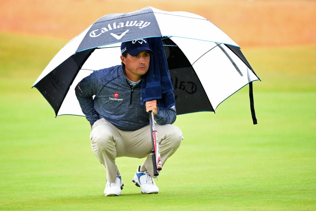 Der Regenschirm ist sehr nützlich während einer Runde Golf bei Regen. US-Golfer Kevin Kisner während Runde zwei bei der British Open 2015 im schottischen Royal Troon. Das Handtuch hänggt unter Schirm, der Schläger ist geschützt und eine Hand wird sogar noch in der Hosentasche warm und trocken gehalten. (Foto: Getty Images).