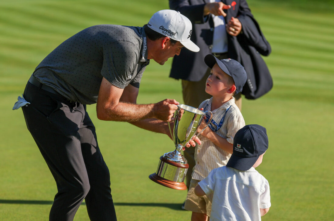 CROMWELL, CONNECTICUT - JUNE 25: Keegan Bradley of the United States is handed a trophy by sons Logan and Cooper after winning during the final round of the Travelers Championship at TPC River Highlands on June 25, 2023 in Cromwell, Connecticut. (Photo by Patrick Smith/Getty Images) tour news