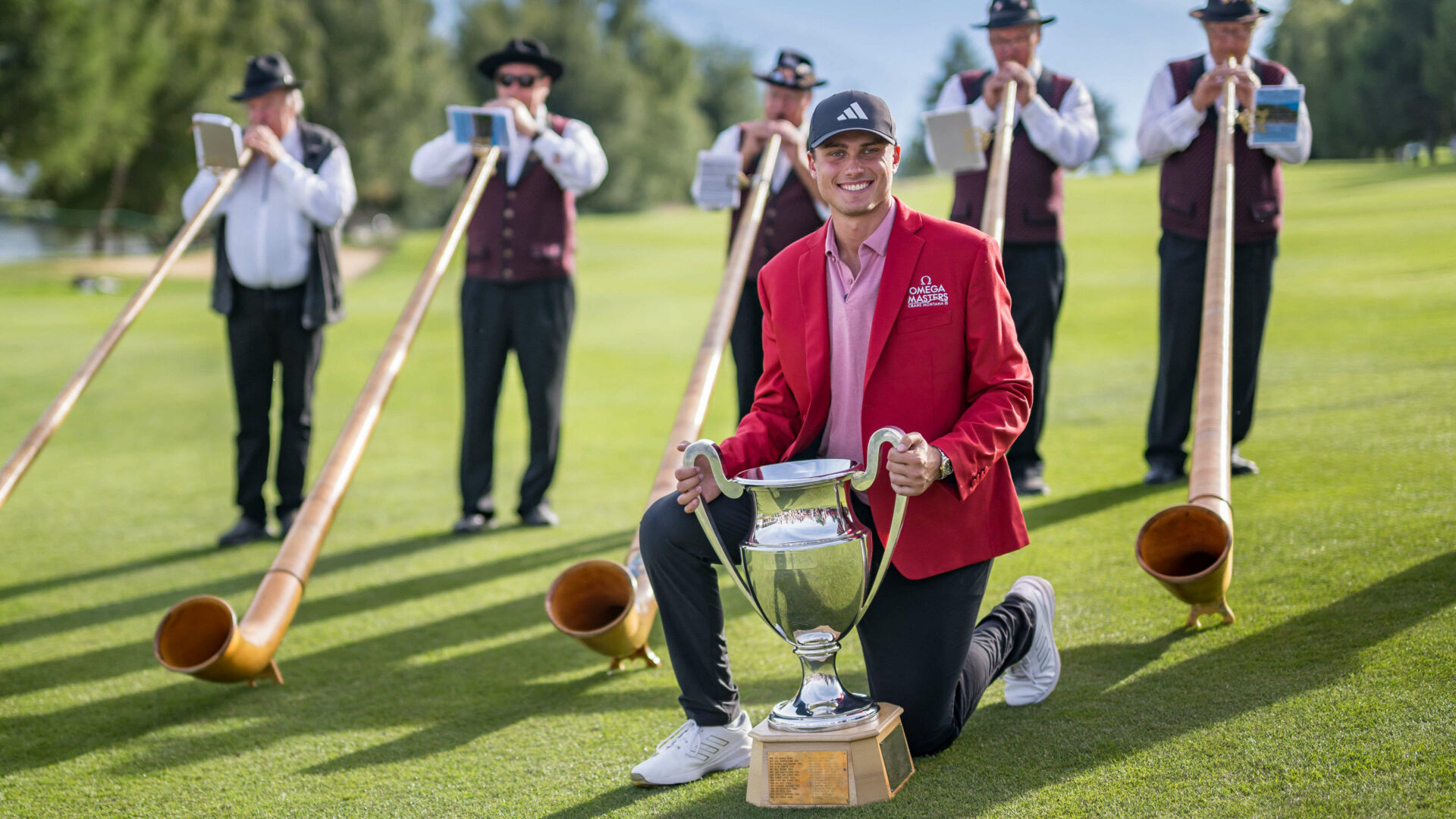 Sweden's Ludvig Aberg poses with the trophy surrounded by alphorn blowers after winning the European Tour's European Masters golf tournament in Crans Montana, western Switzerland on September 3, 2023. (Photo by Fabrice COFFRINI / AFP) (Photo by FABRICE COFFRINI/AFP via Getty Images) tour news