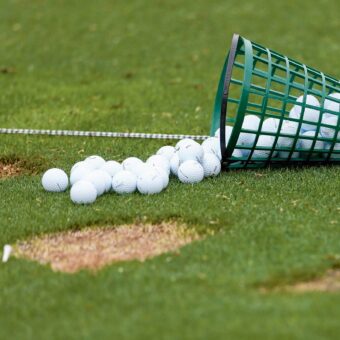 Eimer mit Golfbällen auf Driving Range